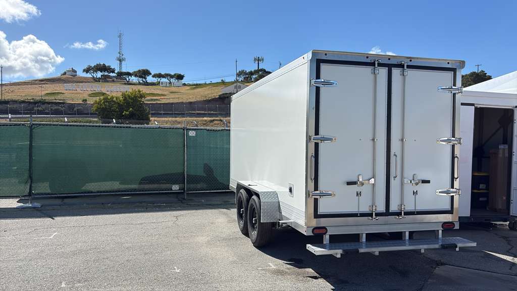 KryoFridge freezer trailer rear and side view in an open lot against desert hills