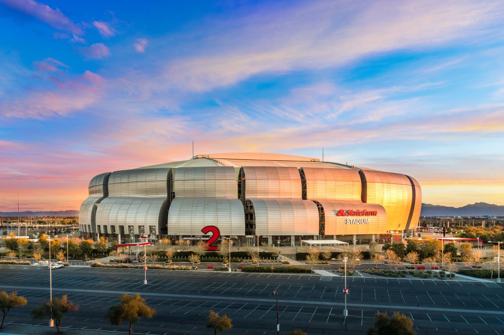 State Farm Stadium in Glendale, Arizona at dusk, the retractable-roof venue that hosts Super Bowls, the Fiesta Bowl and stadium concerts