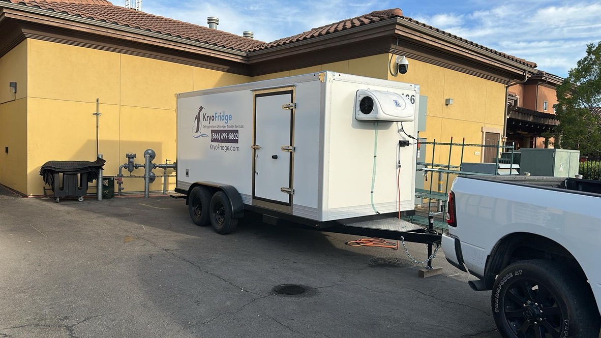 KryoFridge branded freezer trailer parked on site with power connected, one of three sizes available for refrigerated and freezer trailer rentals