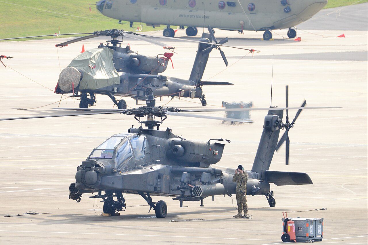 Row of AH-64 Apache attack helicopters on the tarmac, representing Mesa's long-standing Boeing aerospace plant and defense manufacturing