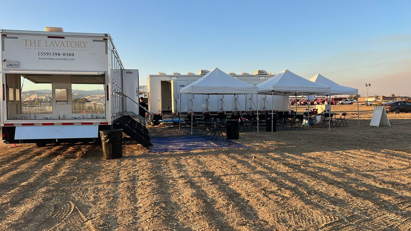 Long white KryoFridge refrigerated trailer staged on an open desert lot with mountains behind
