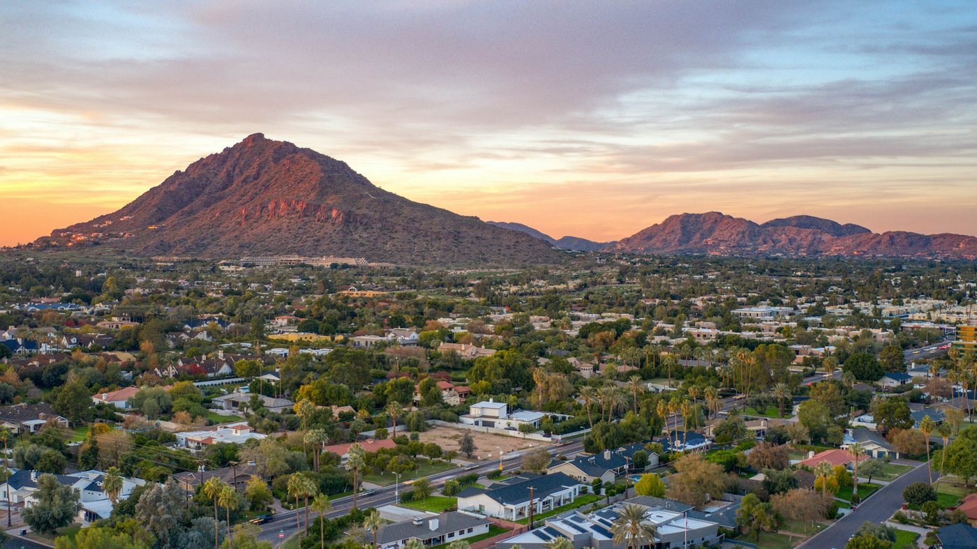 Aerial view of Phoenix, Arizona at golden hour with Camelback Mountain rising over the Valley of the Sun