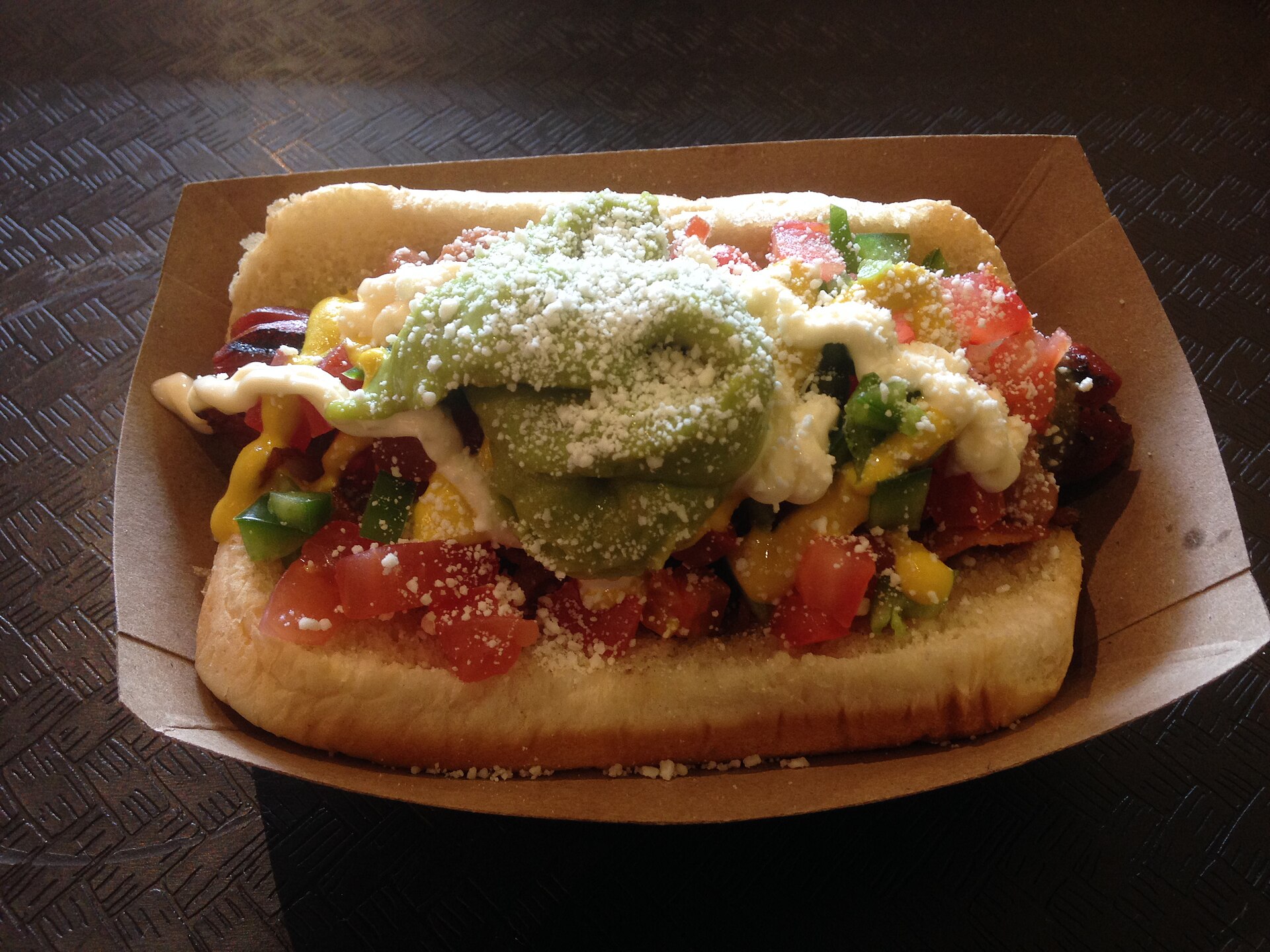 A Sonoran hot dog, the signature street food of Tucson, representing the city's locally owned restaurant scene