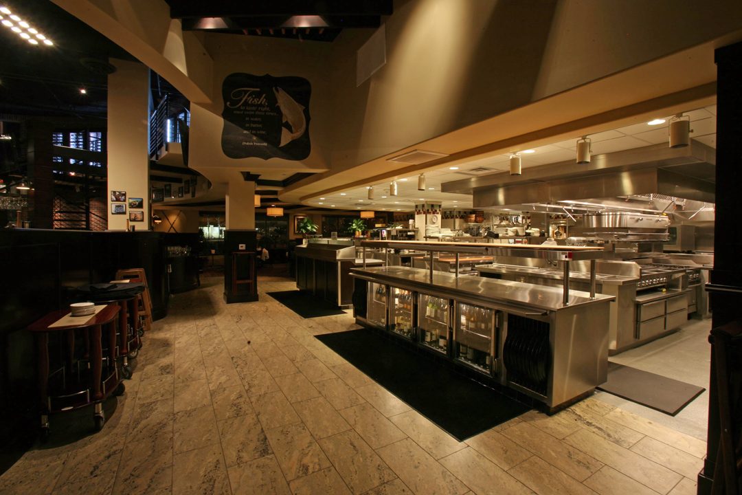 Busy commercial restaurant kitchen line during a dinner service, the kind of Fullerton kitchen KryoFridge backs up with cold storage