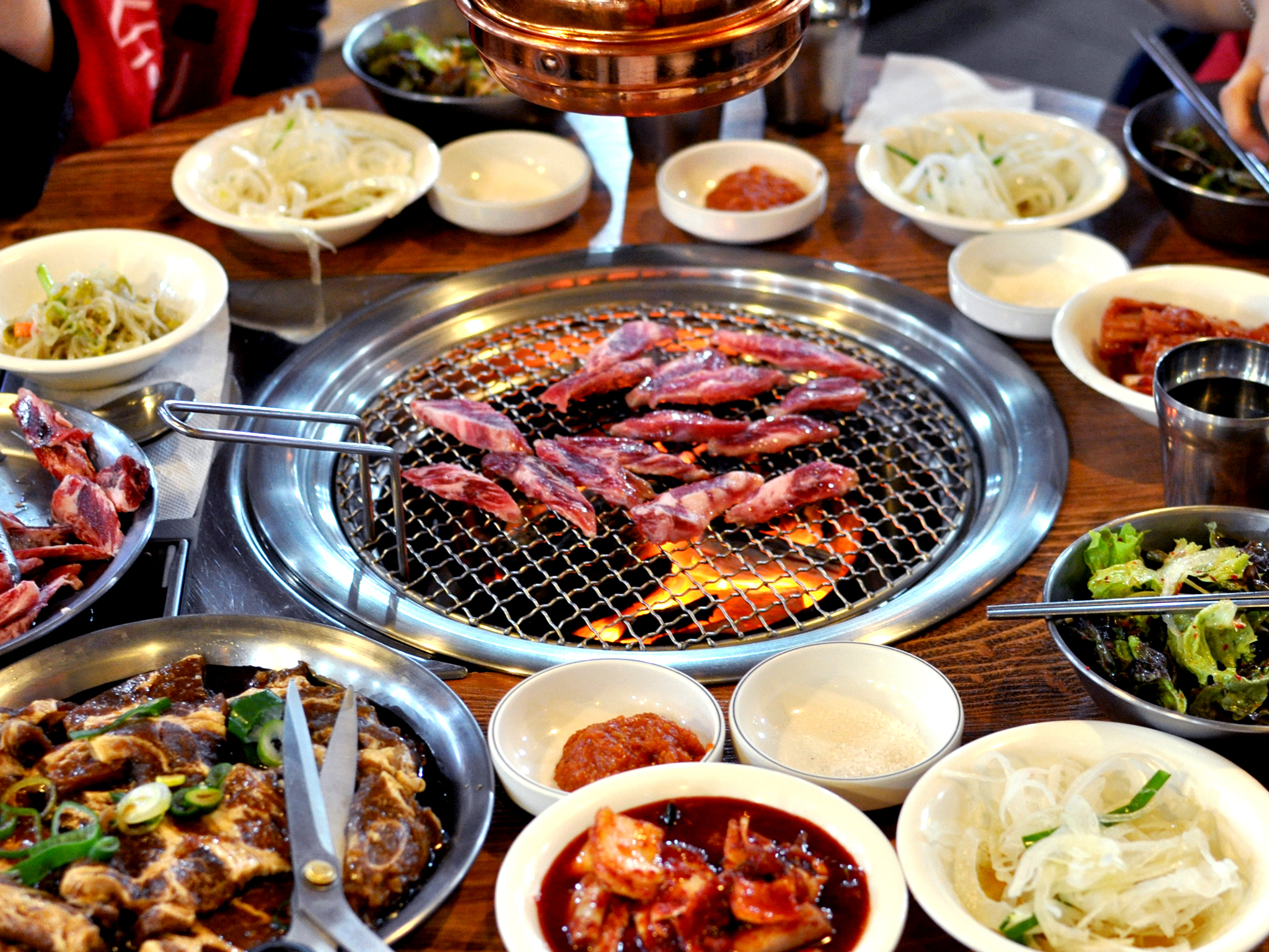 Korean BBQ table spread with marinated meats and banchan in Garden Grove Koreatown