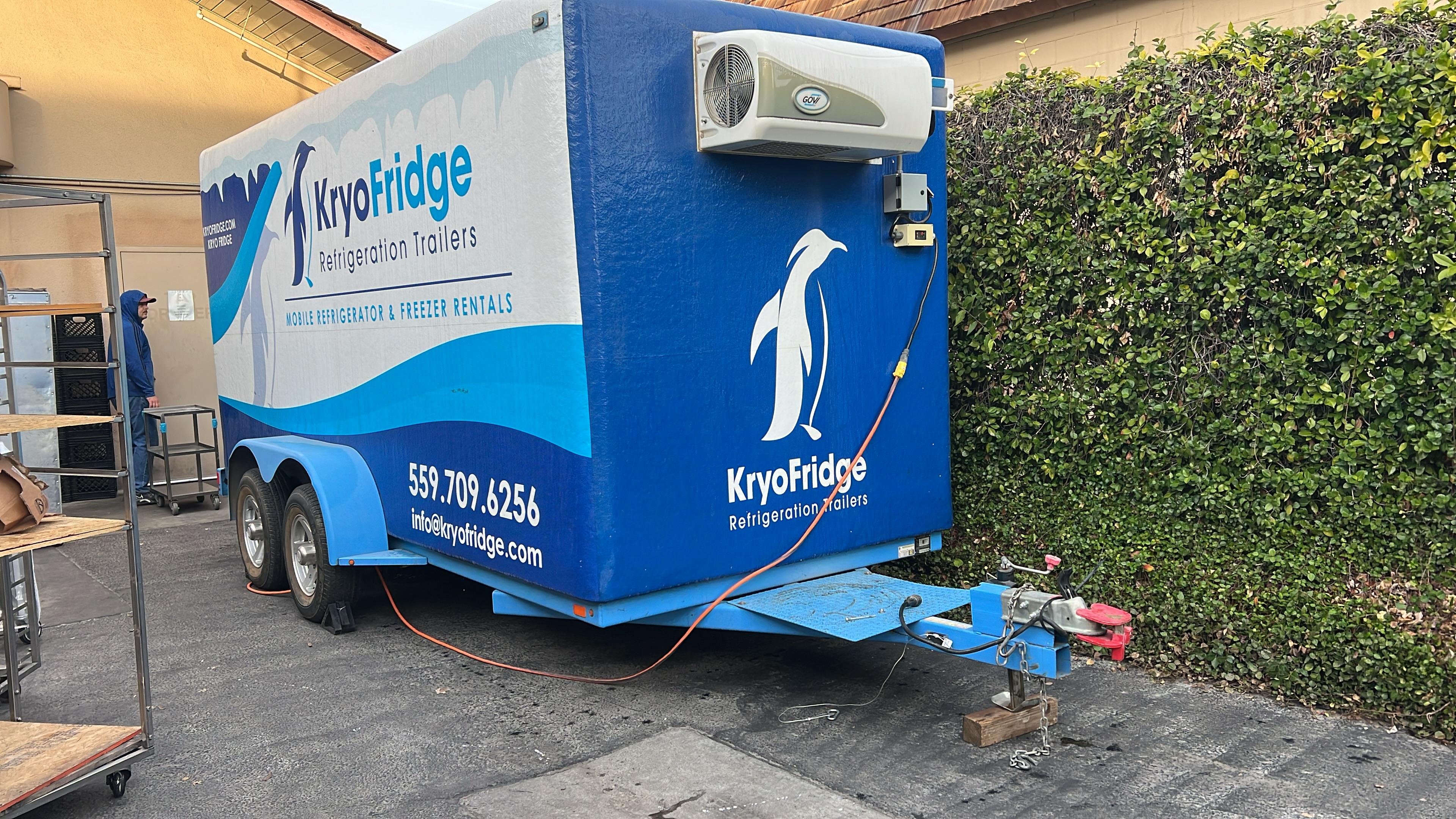 KryoFridge-branded blue and white freezer trailer parked on a Roseville-area job, side profile with the KryoFridge logo