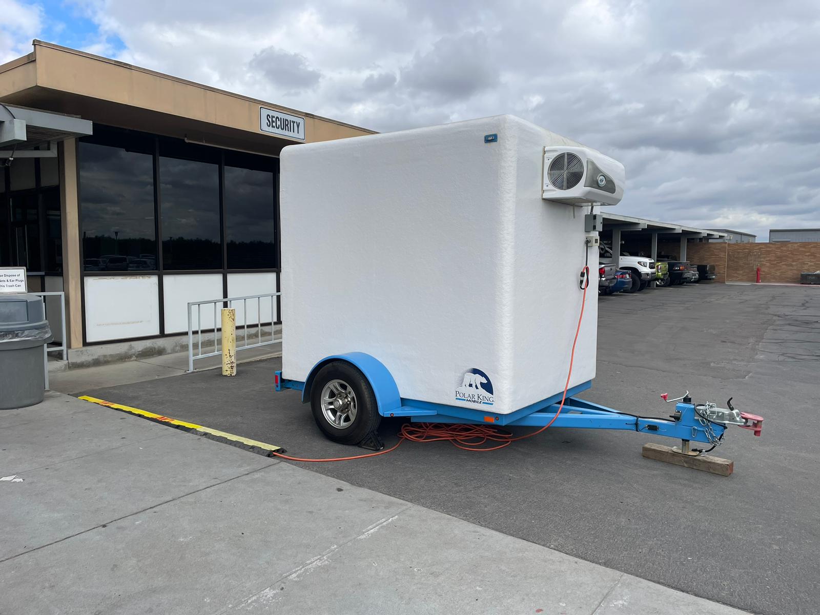 Clean white KryoFridge refrigerated trailer with roof-mounted reefer unit, side profile on a commercial lot