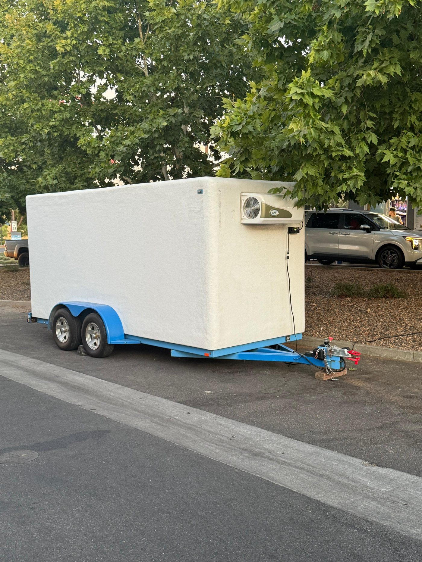 Clean white KryoFridge freezer trailer in side profile, staged for delivery to a Temecula Valley vineyard event