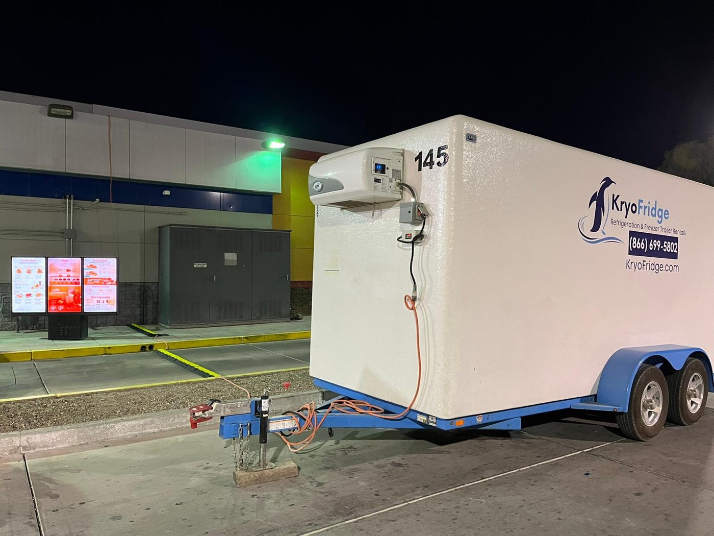 KryoFridge freezer trailer on a night-time emergency deployment at a restaurant, refrigeration unit running
