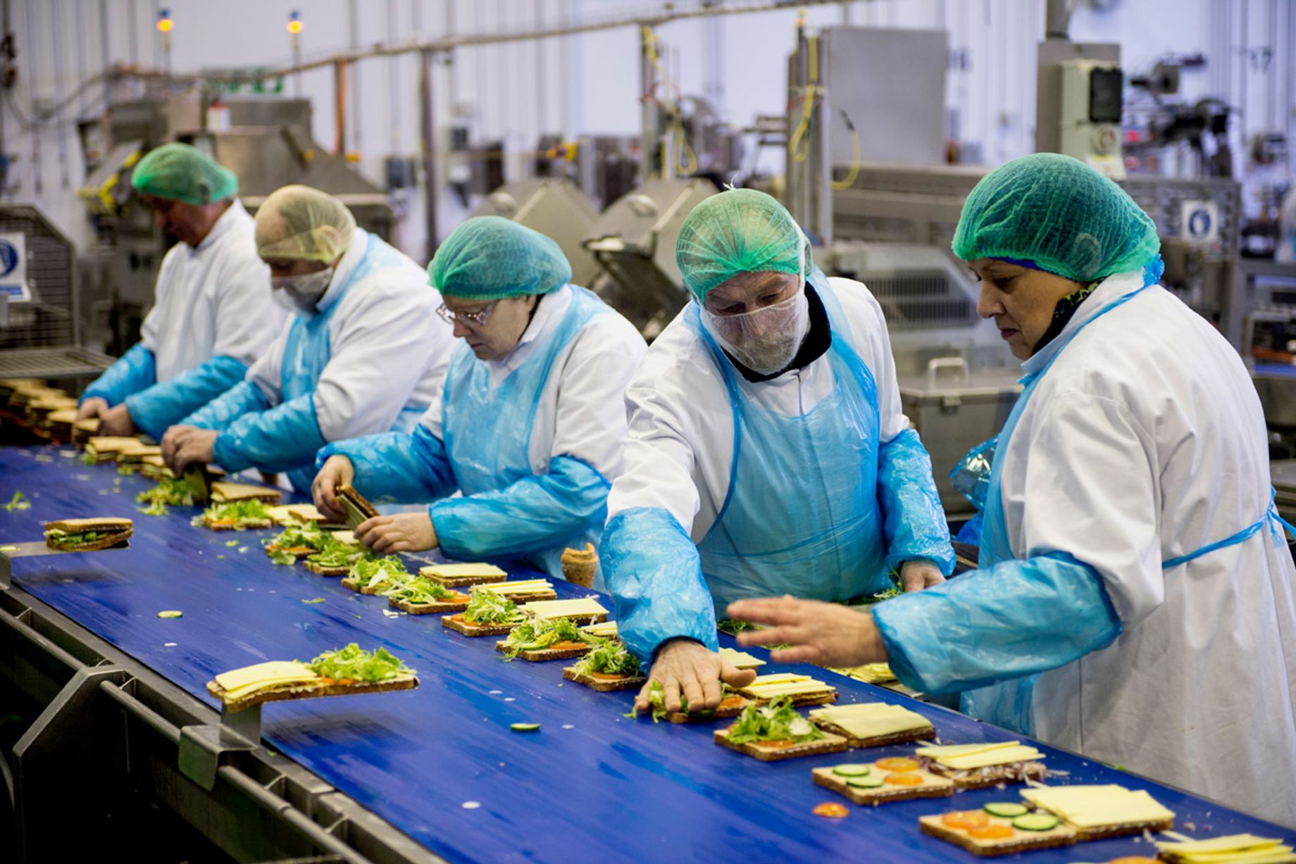 Workers on a food manufacturing production line that depends on cold storage capacity