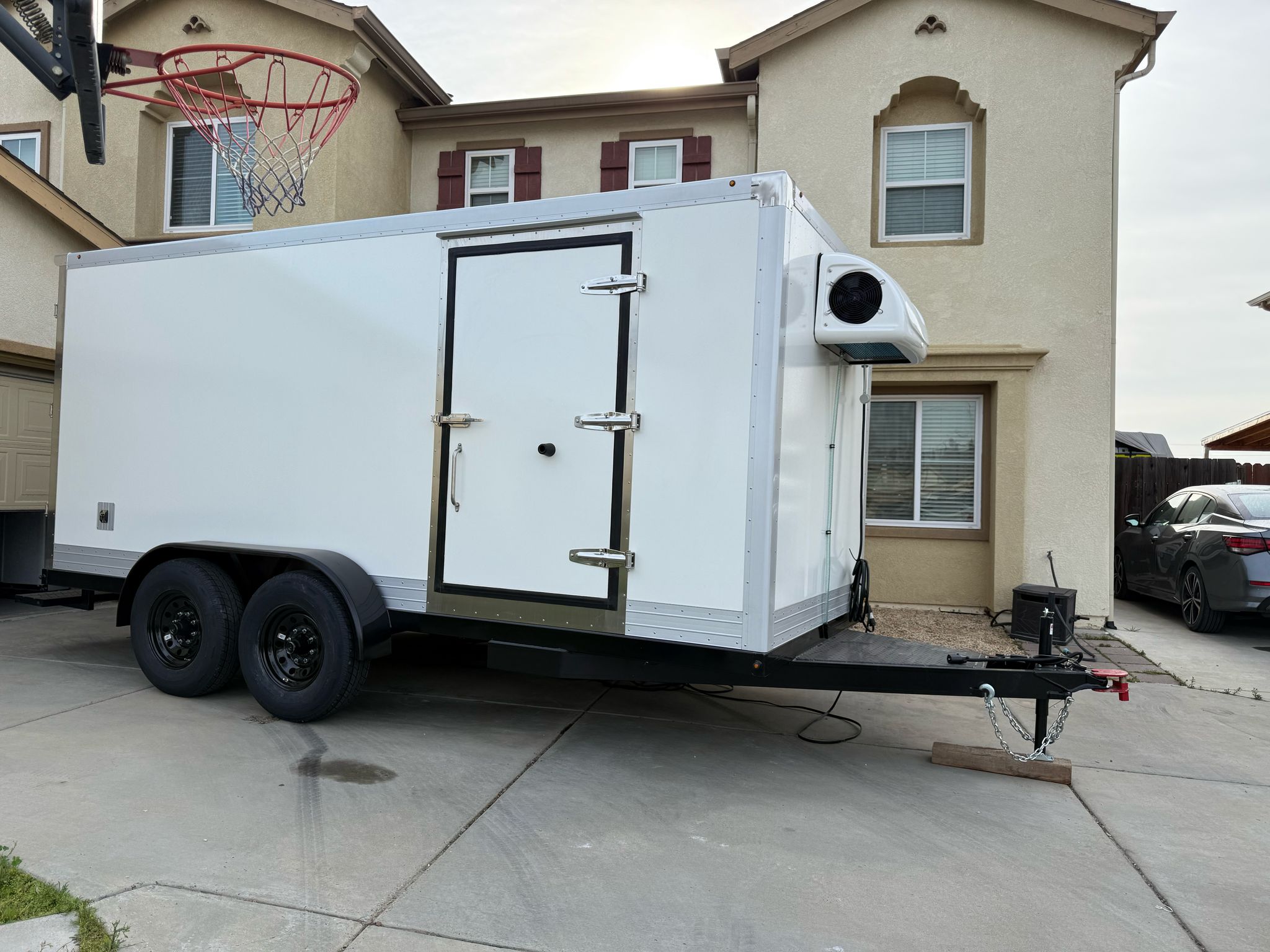 Side profile of a clean white KryoFridge freezer trailer with its refrigeration unit, staged and ready for an Albuquerque cold-storage rental