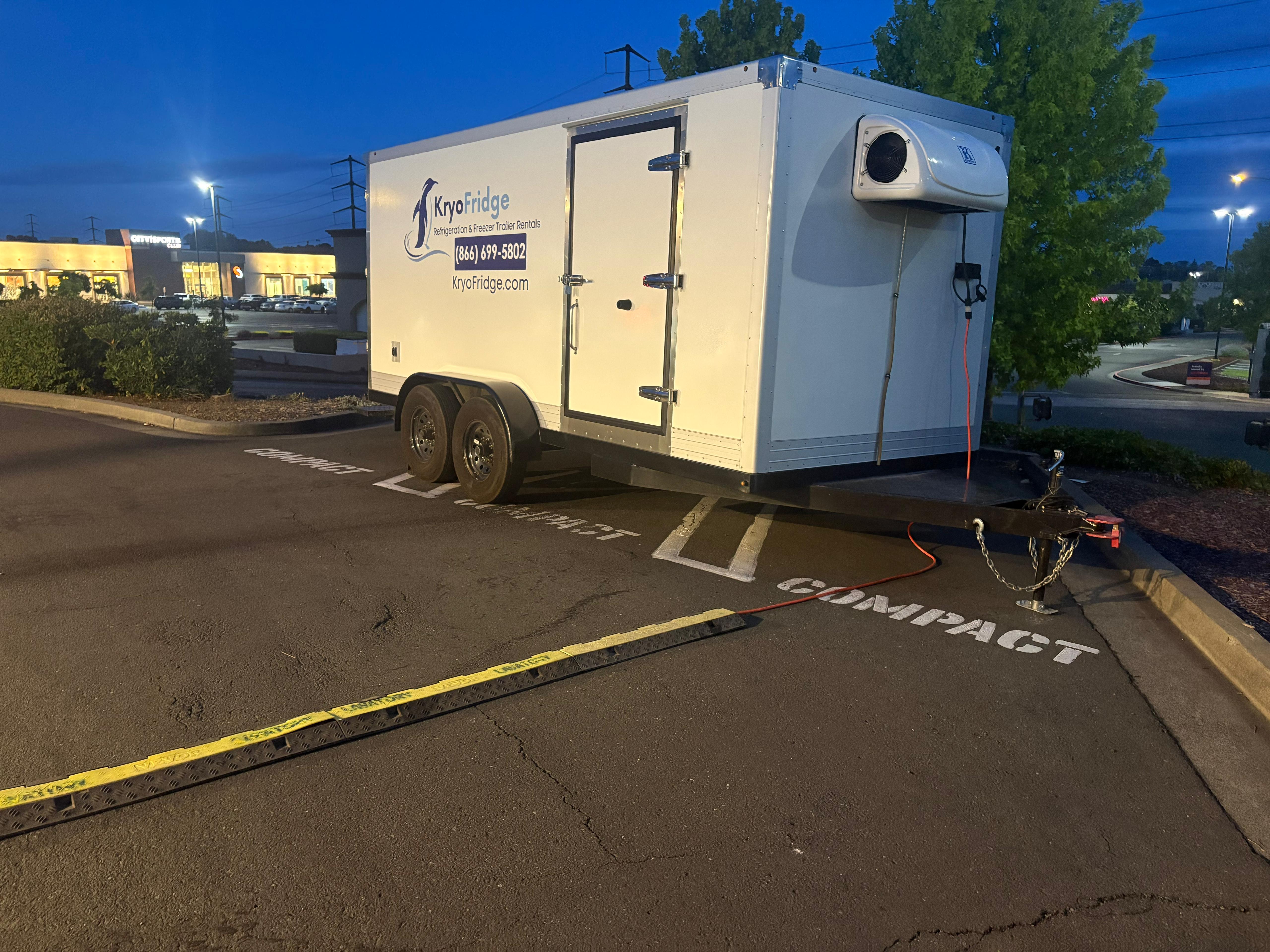 KryoFridge freezer trailer with phone number staged at night in a commercial lot, ready for a marquee-brand cold-storage job