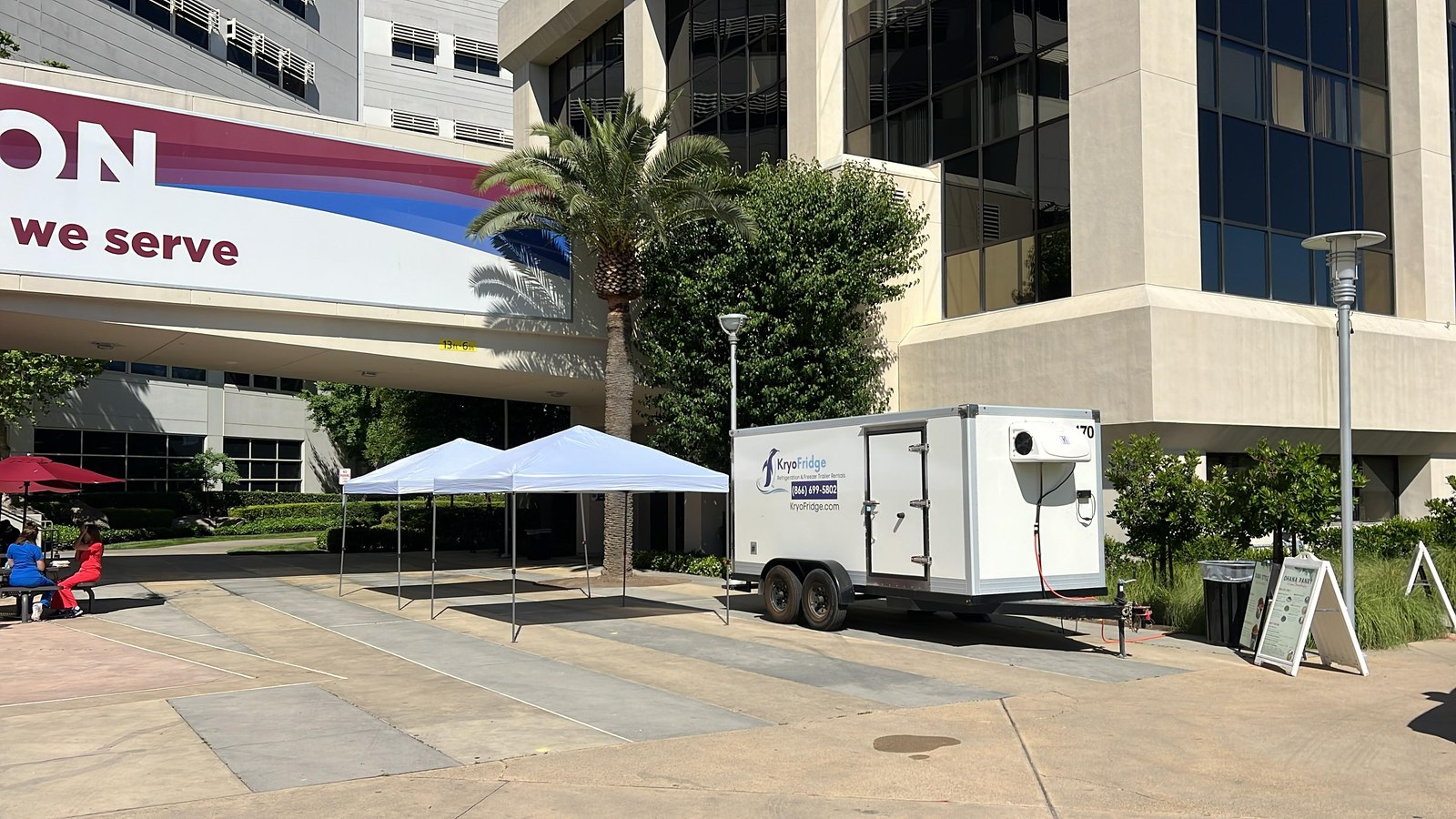 A KryoFridge cooler trailer beside a catering tent at an outdoor evening event in the Phoenix West Valley with string lights overhead